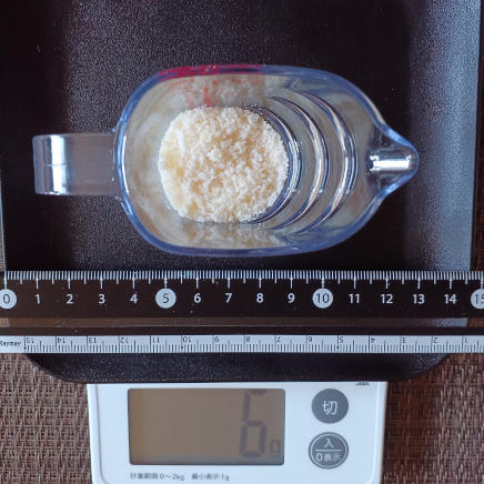 計量カップに入れた大さじ1杯分のパルメザン 6g