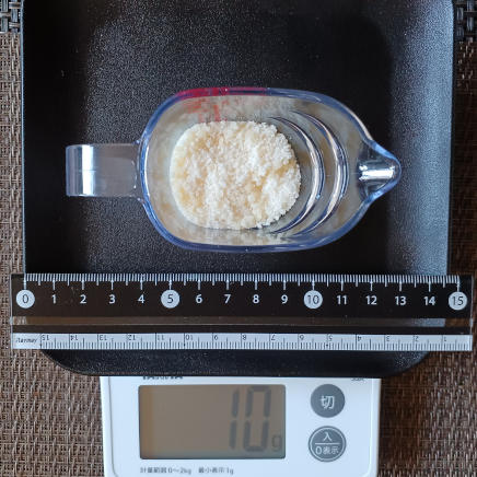 計量カップに入れた10gのパルメザン 10g