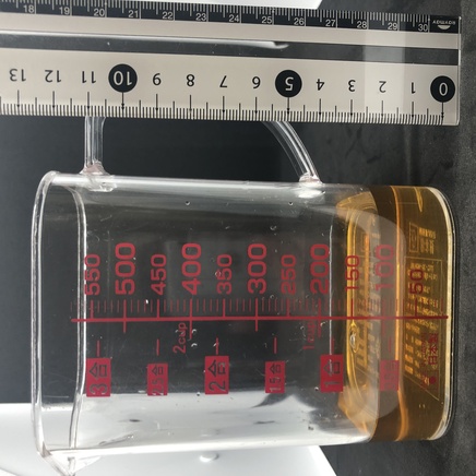 横から見た計量カップに入れた100mlの番茶