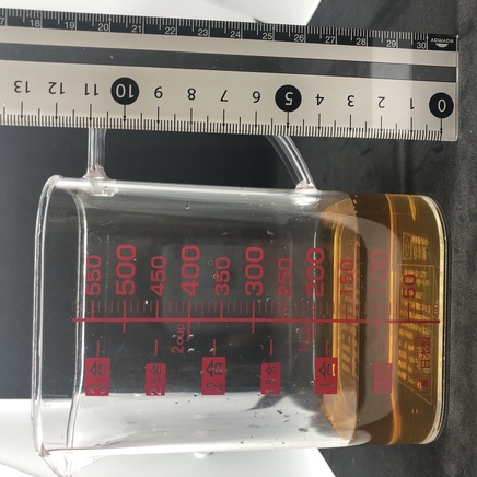 横から見た計量カップに入れた125mlの番茶
