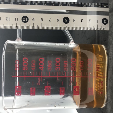 横から見た計量カップに入れた150mlの番茶