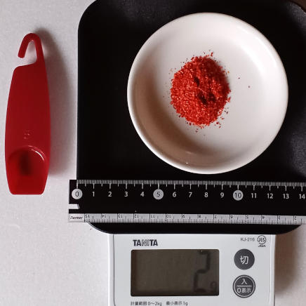 小皿にのせた小さじ1杯2gのチリペッパー