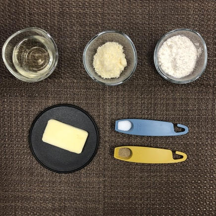 グラタン皿1杯分のエビグラタンに使った調味料（バター・パルメザンチーズ・小麦粉・白ワイン・こしょう・塩）
