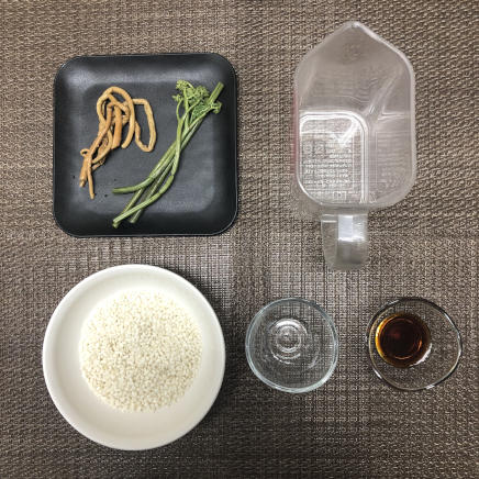 1人前の山菜おこわに使用したもち米・水・しょうゆ・日本酒・干しぜんまい・わらび