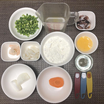 1人前のチヂミに使用したイカ・たこ・シバエビ・こねぎ・玉ねぎ・にんじん・チリペッパー・サラダ油・小麦粉・塩・片栗粉・かつおだし・卵