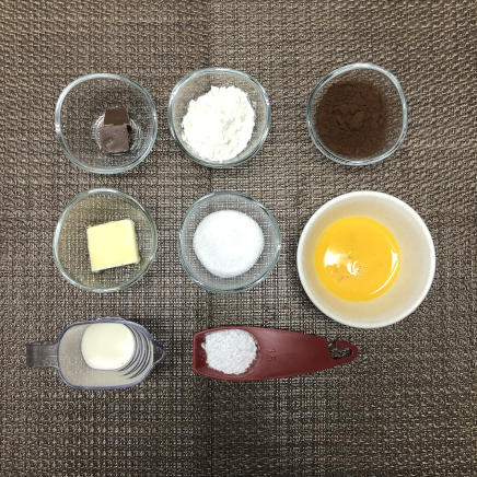 18cm型8等分1ピースのガトーショコラに使った材料（チョコレート・小麦粉・ココア・無塩バター・粉糖・グラニュー糖・生クリーム・卵）