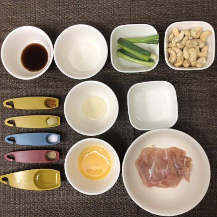 小皿1皿・1人前の鶏肉のカシューナッツ炒めの材料(鶏肉・わけぎ・唐辛子・カシューナッツ・生姜・塩・こしょう・醤油・日本酒・サラダ油・酢・水・卵)