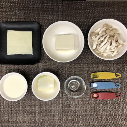 中皿1皿分・1人前の豆腐グラタンに使った材料（木綿豆腐・玉ねぎ・塩・こしょう・ホワイトソース・プロセスチーズ・パセリ・サラダ油・しめじ）