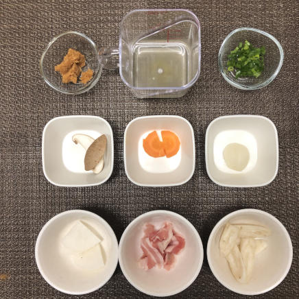1人前のだんご汁に使用した材料(豚肉・にんじん・ごぼう・大根・里芋・しいたけ・こねぎ・昆布だし・麦味噌)