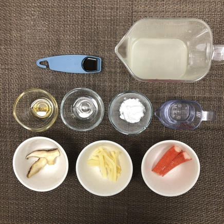 大皿1皿分のあんかけチャーハンに使用した材料と調味料（醤油・鶏がらスープ・日本酒・片栗粉・ごま油・サラダ油・しいたけ・たけのこの水煮・かにかま）