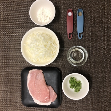大皿1皿・1人前のポークソテーの材料(豚ロース・キャベツの千切り・塩・こしょう・小麦粉・サラダ油・パセリ)