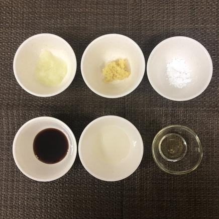 1人前のポークソテーにかけたオニオンソースの材料(玉ねぎのすりおろし・しょうがのすりおろし・醤油・はちみつ・片栗粉・料理酒)