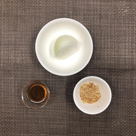 中皿1皿分のオニオンサラダに使った材料（玉ねぎ・和風ドレッシング・かつお節）