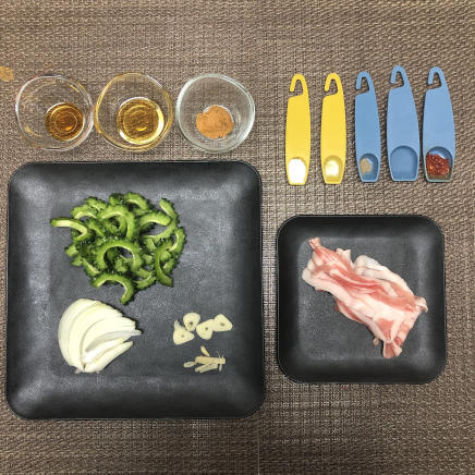 ゴーヤ炒め1人前に使用したゴーヤ・豚肉・玉ねぎ・にんにく・生姜・砂糖・日本酒・しょうゆ・塩・こしょう・味噌・豆板醤・ごま油
