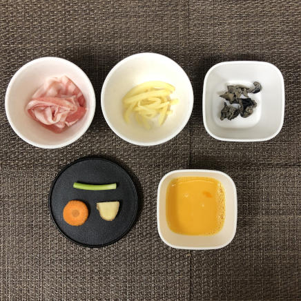 小皿1皿分のきくらげの卵炒めの材料（小ネギ・豚肉・たけのこの缶詰・人参・生姜・きくらげ・卵）