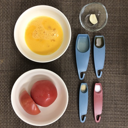 大皿1皿・1人前のトマト炒めの材料(トマト・卵・鶏がらスープ・にんにく・塩・こしょう・ごま油)