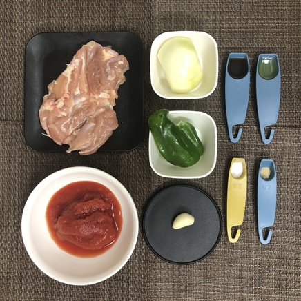 大皿1皿分の鶏肉のトマト煮の材料（鶏肉・玉ねぎ・ピーマン・にんにく・ホールトマト・醤油・塩・こしょう・オリーブオイル）