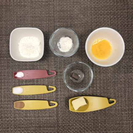 1個分のチョコマドレーヌに使用した材料（小麦粉・強力粉・ベーキングパウダー・グラニュー糖・無塩バター・卵・ココア・チョコレート）
