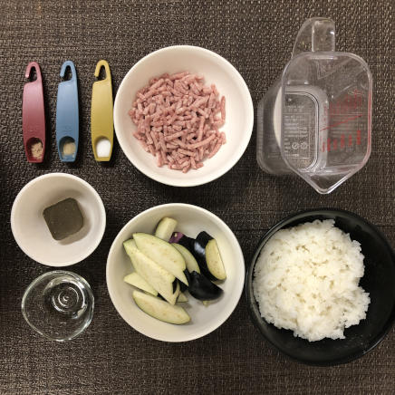 大皿1皿・1人前のなすとひき肉のカレーに使った材料（ご飯・牛ひき肉・豚ひき肉・なす・サラダ油・塩・こしょう・カレールー・水・ナツメグ）