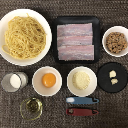 大皿1皿・1人前の納豆カルボナーラの材料(パスタ・納豆・ベーコン・生クリーム・にんにく・パルメザン・卵黄・塩・黒こしょう・オリーブオイル)