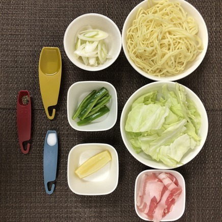 大皿1皿・1人前のレモン焼きそばの材料(蒸し中華めん・キャベツ・レモン・塩・黒こしょう・オリーブオイル・豚肉・ネギ・ピーマン)