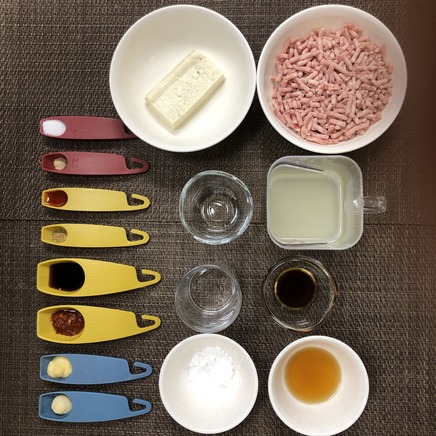丼1杯・1人前の麻婆そばの材料（牛ひき肉・豚挽き肉・木綿豆腐・鶏がらスープ・豆板醬・醤油・オイスターソース・日本酒・塩・こしょう・ラー油・片栗粉・水・にんにく・山椒・おろし生姜・ごま油）