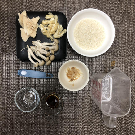 1人前のきのことたけのこの炊き込みご飯に使用した米・水・たけのこの水煮・しめじ・油揚げ・薄口しょうゆ・みりん・塩・かつお節