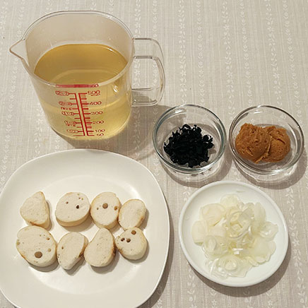 お椀1杯分のわかめと麩の味噌汁に使った材料（かつおだし、乾燥わかめ、味噌、長ねぎ、麩）