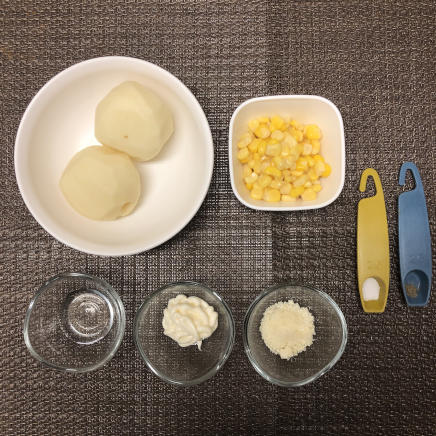 中皿1皿・1人前のコーンのポテトサラダに使用した材料（じゃがいも・コーン缶・酢・塩・こしょう・マヨネーズ・粉チーズ）