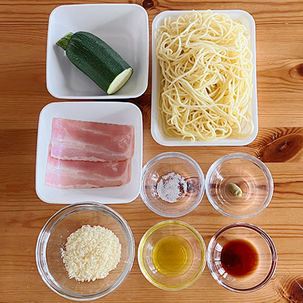 大皿1皿分のズッキーニとベーコンの和風パスタに使った材料(茹でパスタ、ベーコン、パルメザン、ズッキーニ、柚子胡椒、塩、オリーブオイル、醤油)