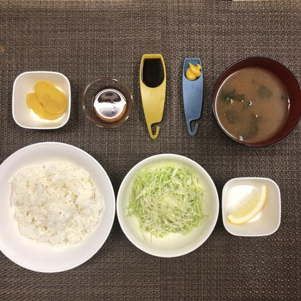 1人前のチキンカツ定食に使った材料(ご飯・わかめの味噌汁・キャベツの千切り・和風ドレッシング・ウスターソース・たくあん・レモン・からし)