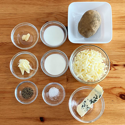 グラタン皿1皿分・1人前のゴルゴンゾーラポテトグラタンに使った材料(じゃがいも、牛乳、生クリーム、ブルーチーズ、バター、おろしにんにく、プロセスチーズ、塩、こしょう)