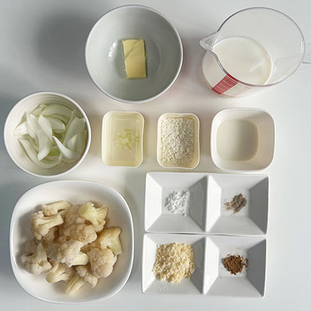 グラタン皿1皿分のカリフラワーのグラタンに使った材料（カリフラワー、玉ねぎ、にんにく、牛乳、小麦粉、バター、ナツメグ、パルメザン、塩、こしょう、酢）
