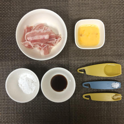 小皿1皿・1人前の豚肉の唐揚げに使った材料(豚肉・卵・片栗粉・料理酒・砂糖・醤油・おろしにんにく)