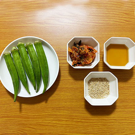 中鉢1杯分のオクラキムチに使用した材料（オクラ、キムチ、ごま油、炒りごま）