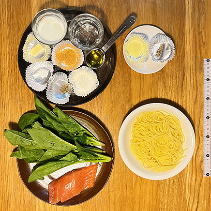 深皿(中)1皿分のサーモンのクリームパスタに使用した材料(パスタ、サーモン、ほうれん草、牛乳、水、バター、コンソメ)、塩、黒こしょう、小麦粉、オリーブオイル、パルメザン)