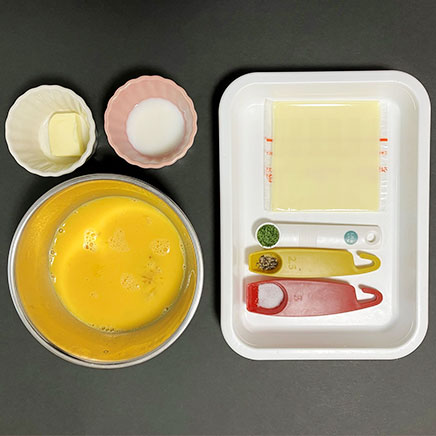 中皿1皿・卵2個分のチーズオムレツに使用した材料(卵、牛乳、プロセスチーズ、塩、こしょう、バター、乾燥パセリ)