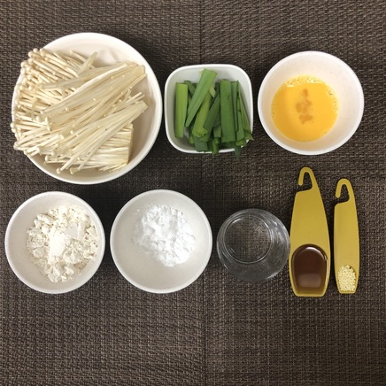 平皿1皿・1人前のえのきチヂミの材料(えのき・ニラ・卵・片栗粉・薄力粉・顆粒中華だし・水・ごま油)