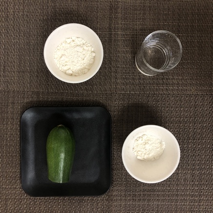 中皿1皿・4切れ分のズッキーニの天ぷらの材料(ズッキーニ・天ぷら粉(まぶす用)・天ぷら粉(衣用)・水)