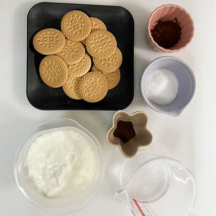 ガラス製の器(8.5cm×8.5cm×4.5cm)1つ分のヨーグルトティラミスに使用した材料（ヨーグルト、ビスケット、インスタントコーヒー、水、グラニュー糖、ココア）