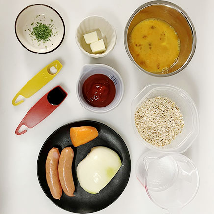 深皿（大）1皿分のオートミールオムライスに使用した材料（オートミール、水、人参、玉ねぎ、ウインナー、バター、ケチャップ、醤油、水、卵、塩、乾燥パセリ）
