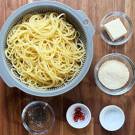 中皿1皿分のチーズペペロンチーノの材料(パスタ、バター、パルメザン、唐辛子、塩、黒こしょう)