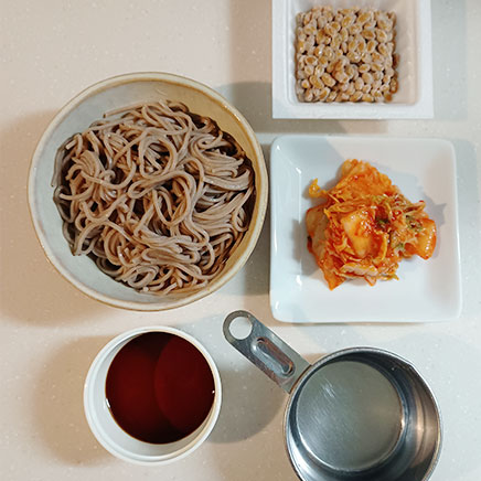 丼1杯分の納豆キムチそばに使用した材料（そば、納豆、キムチ、めんつゆ（3倍濃縮）、水）