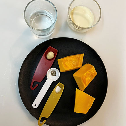 マグカップ1杯分の豆乳かぼちゃスープに使用した材料(かぼちゃ、豆乳、水、おろしにんにく、塩、黒こしょう)