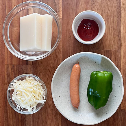 餅2個分のもちピザに使用した材料(餅、ピーマン、ウインナー、ケチャップ、プロセスチーズ)
